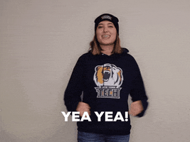 Video gif. Woman wearing a New York Tech sweatshirt smiles and pumps her arms in towards her body like she's cheering and mouthing the words, "Yea Yea!"