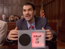 Video gif. A man sitting in trial is getting annoyed and he has a box that flashes red and says, "Wrap it up!" He pounds the box and points at us while curling his lips in anger.