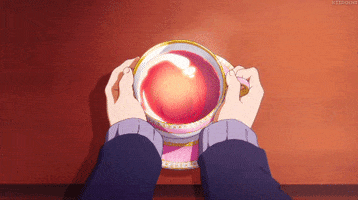 Anime gif. Two hands resting on a table hold a steaming cup of tea.