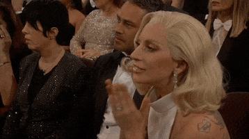 Celebrity gif. Lady Gaga at the 2016 Oscars, sitting in audience and gesturing "thank you" with her hands.