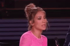 An animated gif of Jennifer Lopez crossing her arms in an annoyed huf.