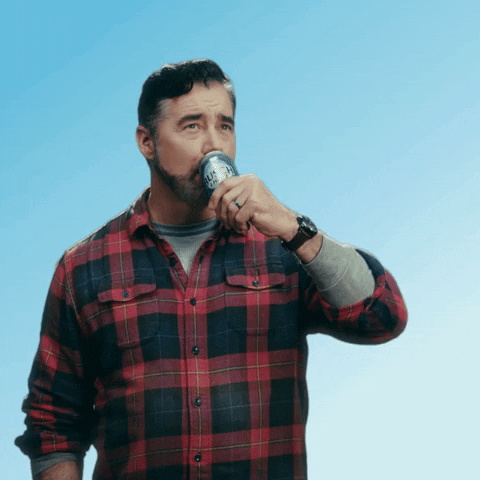 Sponsored gif. Gerald Downey takes a satiflying swig of Busch Light beer, closing his eyes like he's relaxing into a moment of complete happiness. He drops the beer back down to his chest and gives us a quick, friendly cheers. Text, "Ahhh."
