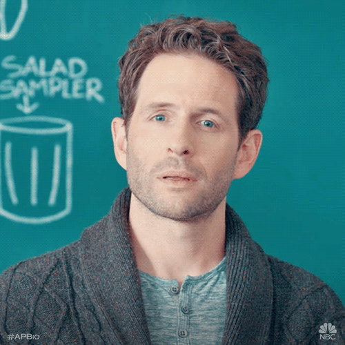 TV gif. Standing in front of a chalkboard, Glenn Howerton, as Jack in AP Bio stares blankly, slightly smiling.