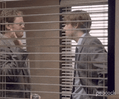 The Office gif. Characters Jim and Dwight high five in the conference room. 
