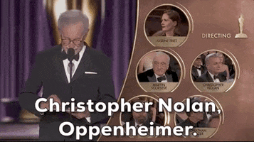 Oscars 2024 GIF. Steven Spielberg effortlessly opens the envelope and announces, "Christopher Nolan. Oppenheimer" for Best Director. We see each of the nominees on the right. 