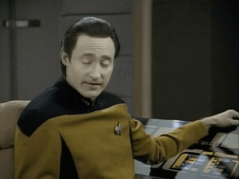 TV gif. Brent Spiner as Data on Star Trek bursts into laughter.