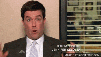 The Office gif. Ed Helms as Andy Bernard sits for an interview. He holds up both hands with crossed fingers with a dramatic expression on his face.