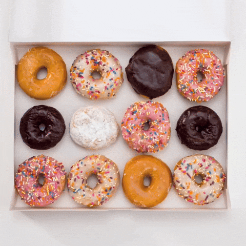 Sponsored gif. White Dunkin’ Donuts box opens to reveal 12 donuts in varying flavors and colors.