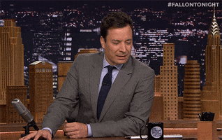 Tonight Show gif. Jimmy Fallon leans on his elbow, looks at his palm and shrugs.