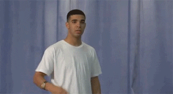 Celebrity gif. Young Drake leans backwards and pretends to pull out an imaginary gun from his pocket, almost like a cowboy in a standoff would. He says, “boom,” and lifts his hands up.