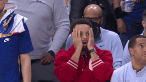 Sports gif. Steph Curry of the Golden State Warriors sits on the sidelines in street clothes, with his hands on his cheeks, looking up like he's looking at a scoreboard in utter disbelief.