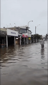 Car Drives Along Flooded Main Street