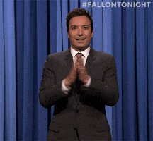 TV gif. Jimmy Fallon on the Tonight Show does an awkward slow clap and turns his hands to try again but failing and still being awkward.
