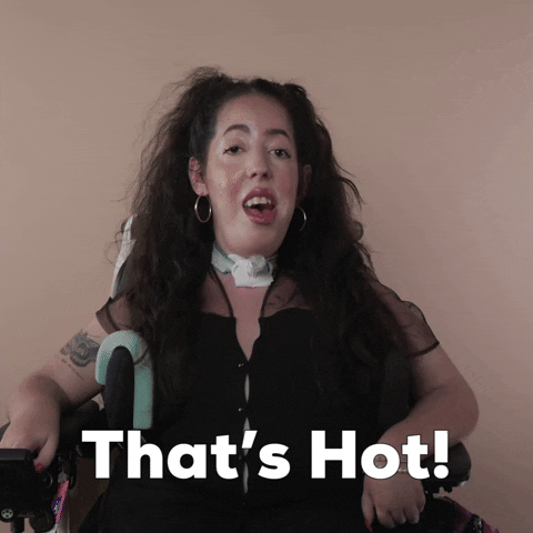 Reaction gif. A Disabled white woman with muscular dystrophy with wavy brown half up half down with two pigtails on top, seated in her motorized wheelchair, says with attitude, "That's hot."
