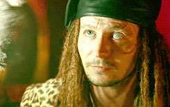 Movie gif. Gary Oldman as Drexl Spivey in True Romance looks up flirtatiously, licking his teeth, and winking with his good eye.