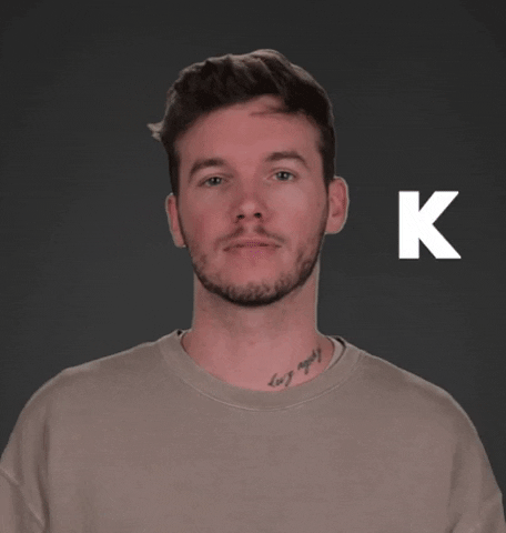 Celebrity gif. Dalton Fowler looks at us bored with a glitchy, white letter K next to him.