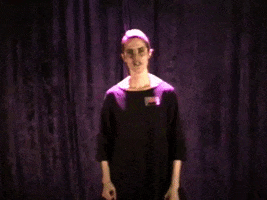 Video gif. A woman standing in front of a black curtain staring us down. She passionately tells us to "Just do it!" while pausing for dramatic effect and ending with, "Now!" 
