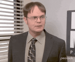 The Office gif. Rainn Wilson as Dwight stands in pensive thought. Text. "Hmmm"
