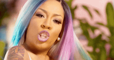 Celebrity gif. K Michelle looks at us with a serious expression and points directly at us.