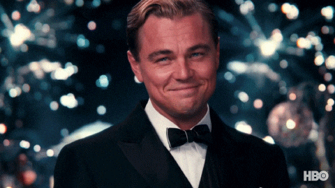 Gif s připíjejícím Leonardem DiCapriem šampaňským na pozadí vybuchujících ohňostrojů ve filmu Velký Gatsby.