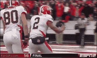 Sports gif. Football player holds up his hand for a high five as he runs toward the edge of the field where a referee backs away from him, refusing the high five.