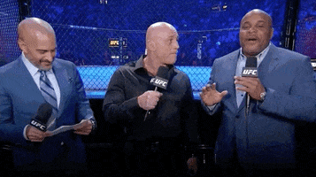 Video gif. Joe Rogan, Daniel Cormier, and Jon Anik are at a UFC fight. Jon speaks into the microphone with conviction. "Imagine a young girl's gonna go watch Taylor Swift next week! That's how I feel." Daniel Cormier and Joe Rogan react with a big smile and laugh. 