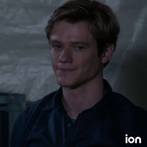 TV gif. Lucas Till as Angus MacGyver on MacGyver chuckles, smiles, and then turns to look at something.