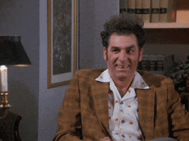 Seinfeld gif. In an office, Michael Richards as Kramer raises his eyebrows and nods at Phil Morris as Jackie Chiles who also smiles and nods.