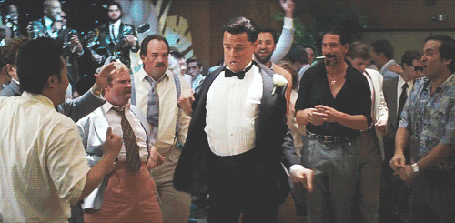 Movie gif. Leonardo Dicaprio as Jordan in Wolf of Wall Street dances awkwardly in front of a group of people.