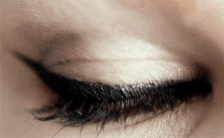 Video gif. An extreme close-up shot of a woman's eye shows the eye blinking repeatedly.