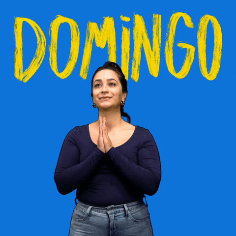 Video gif. Woman shakes her head as she does the sign of the cross, each movement revealing the lines of a white cross, before she holds her hands together in prayer. Text, in Spanish, "Domingo."