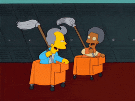 The Simpsons gif. Two smiling characters sitting in orange mop buckets with mops flung over their shoulders race down a school hallway, past an endless line of lockers.