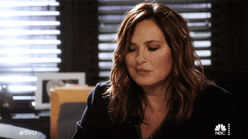 TV gif. Mariska Hargitay as Olivia in Law and Order: SVU. She smirks at something and leans down to scratch her forehead in bemusement. 