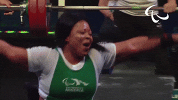 Sports gif. Nigerian Paralympian powerlifter Lucy Ejike closes her eyes and does a happy dance in her wheelchair.