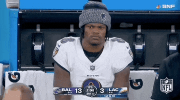 Sports gif. Marlon Humphrey of the Baltimore Ravens sits on the sidelines with a concerned or disappointed frown on his face, video zooming in and out for effect.