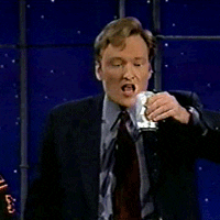 TV gif. Conan O'Brien holds a can of beer up and pours it into his open mouth, but most of the contents spill over down his face and clothes.