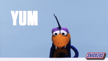 Ad gif. A Lizard-like puppet looks at us, smacking his lips, and rubbing his hand on his tummy. TExt, “Tum.” The Snickers logo is in the corner.