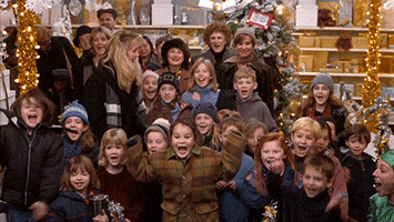Movie gif. Will Ferrell as Buddy in Elf jumps up and down, clapping his hands in excitement. Behind him are a group of young children also jumping up and down cheering with excitement like he is. Parents stand behind the children smiling.