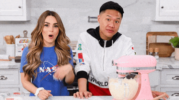 Celebrity gif. YouTuber Rosanna Pansino and TV personality Tim Chantarangsu raise their left palm then right in a "this or that" gesture.
