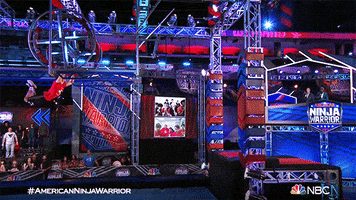 Reality TV gif. Person on American Ninja Warrior swings from above a pool of water to get to a platform. They swing their legs all the way up and then accidentally fall straight down into the water, making a big splash.