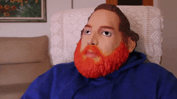 Celebrity gif. Actor Limoo gives a thumbs-up while wearing a silicone mask that resembles his actual face, which is round with a red beard and brown hair.