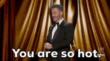 Oscars 2024 gif. Host Jimmy Kimmel stands on stage with his hands clasped and addresses Ryan Gosling in the crowd by sincerely saying, "You are so hot." He shakes his head in utter disbelief. 