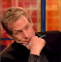 Sports gif. Skip Bayless rests his chin in his hand as he shakes his head with irritation on his face.