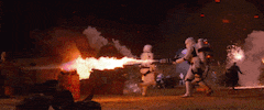 Movie gif. Stormtroopers from Star Wars are setting things on fire with flame blowers.