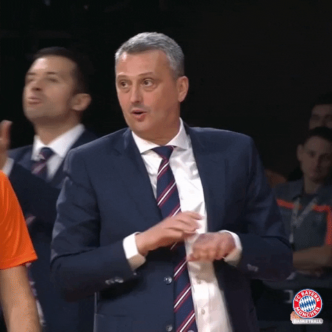 Sports gif. Dejan Radonjić, head coach of the Bayern Munich basketball team, rubs his hands together while pursing his lips and tilting his face back and forth in a silly manner.