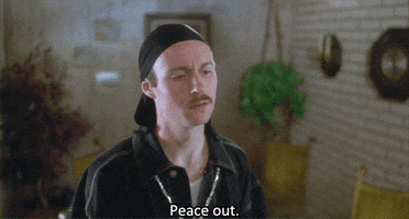 Movie gif. Aaron Ruell as Kip in Napoleon Dynamite wears a durag and a gold chain as he holds up a peace sign and says, "Peace out," then turns to walk away.