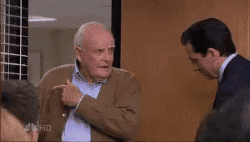 The Office gif. John Ingle as Robert Dunder speaks while Steve Carrell as Michael Scott nods and smiles and shuts him out of the conference room with the door.