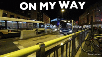 Video gif. Procession of buses travel down a city street at night. Text, "On my way."