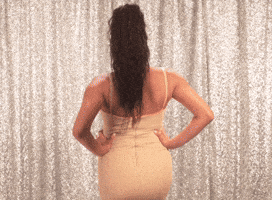 Celebrity gif. Shay Mitchell stands with her hands on her hips. She tosses her hair seductively as she turns around and rubs her baby bump. Text, "You want dis?"
