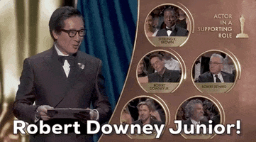 Oscars 2024 GIF. Split screen of Ke Huy Quan and the Best Supporting Actor nominees as he announces excitedly, “Robert Downey Junior!”